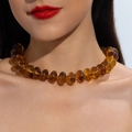 Close-up of vibrant amber acrylic beaded necklace on model with translucent disc beads - Amber Marble(31101)