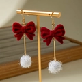 Red velvet bow earrings with festive white tinsel pom-poms on a gold jewelry stand - Red Bow White Fur Ball Style (31416-ear-red-EP)