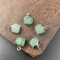 Five faceted green aventurine gemstone pendants with silver-tone loops on a wood background - Green Aventurine