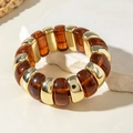 Detail of amber acrylic and gold polished metal tube bracelet on white stone - Amber Blocks and Gold Metal Blocks Patchwork Bracelet (30879)