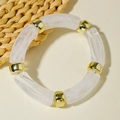 Detail of white marble acrylic tube bracelet with golden spacers on a cream background - White Marble Tube Splicing