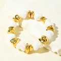 Detailed macro view of iridescent heart beads and golden spacer beads on a stone surface - Iridescent Heart Beads and Gold Irregular Spacer Beads Bracelet (31603)