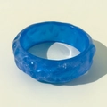 Macro shot of blue translucent resin bangle with irregular rock texture and glossy finish - Blue Uneven Ice Rock Texture Style (31640-bra-blue)