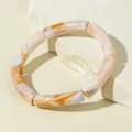 Detailed close-up of amber acrylic curved beads on a minimalist bamboo style bracelet - Tortoise Pattern Bamboo Shaped Beaded Bangle (31610)