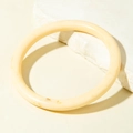 Close-up of a minimalist cream acrylic curved tube bracelet with smooth polished finish - Light Creamy White Round Bar Bangle (31611)