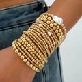 Stijlvolle meerlaagse gouden kralenarmband set met witte parels op de pols van een model - Goud (31659-bra-G-EP)