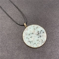 Round light blue natural stone necklace with gold rim and black cord pendant - Kiwi Stone