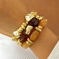 Dettaglio di bracciali impilati con perle dorate, ambrate e in resina scura sul polso - Set da 3 Pezzi Oro Caffè Ambra Chiaro (31622-bra-brown-EP)