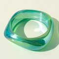 Macro view of a turquoise translucent resin bangle with iridescent holographic finish - Iridescent Emerald Green