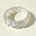 Macro view of transparent chunky resin ring with bubble wave design and glossy texture - White