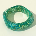Détail d'un large bracelet en résine verte avec des paillettes et sequins colorés - Style de Paillettes de Cœur Gravé (31619)