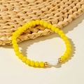 Detail of yellow faceted crystal bead bracelet with a white shell flower pendant - Yellow