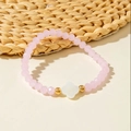 Detail of pink crystal beaded bracelet with white shell clover charm and gold accents - Pink