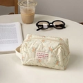 Quilted floral makeup bag in beige with orange flowers and side carry handle - Cream Floral