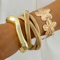 Dettaglio di tre bracciali punk dorati con motivi floreali e trame a spirale lucide - Set da 3 Pezzi Oro (31663-bra-G-EP)