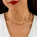 Close-up of chunky gold punk choker with bold metal spikes worn on the collarbone - Spike Studded Style (31549-nek-G-EP)