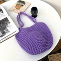 Purple handmade crochet shoulder bag with open semi-circular design on a white table - Violet