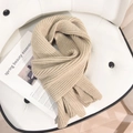 Dicker beiger Strickschal aus hochwertigem warmem Stoff präsentiert auf einem Ledersessel - Beige