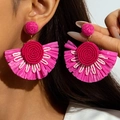 Detalle de pendientes de abanico de rafia fucsia con cuentas tejidas a mano para verano - Rosa Rojo