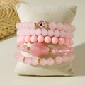 Detail of 5-piece pink beaded bracelet set with evil eye and heart charms on a pillow - Pink 5Pcs Set (31129-bra-pink-EP)