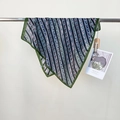 Blue silk scarf with colorful horse print and dark green border hanging on a metal rod - Green Trim / 68*68cm