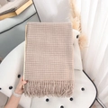 Beige and brown plaid faux cashmere scarf with long tassels displayed on a white chair - Beige