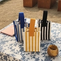 Tre borse shopper in tela a righe gialle, blu e nere su un tavolo da picnic - Striscia Blu Chiaro