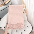 Pink and white plaid cashmere-like scarf with fringe on a white tufted chair - Pink