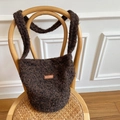 Deep brown plush bucket bag with vintage leather patch on a woven chair - Dark Brown