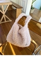 Dettaglio ravvicinato di una borsa a spalla rosa in finta pelliccia con fibbia in metallo - Rosa