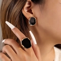 Dettaglio del set di gioielli in smalto nero con bordo dorato irregolare sulla modella - Set Anello e Orecchini Irregolari Oro Nero (25635-black)