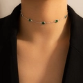 Detalle de un collar con piedras esmeralda verdes en una modelo con chaqueta negra - Collar / Plateado con Piedra Verde (15633)