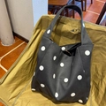 Schwarze gepunktete Wildleder-Tragetasche mit großen weißen Punkten auf Stuhl - Schwarzer Polka Dot