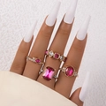 Detail von Ringen mit rosa Edelsteinen und weißen Zirkonia auf Modelhand mit weißen Nägeln - Geometrischer Edelstein-Stil (23643-rose red) / 4-teiliges Set / Fuchsia