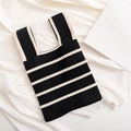 Elegante bolso de punto a rayas blancas y negras con textura suave en fondo blanco - Negro