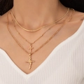 Three-layer gold necklace set featuring rose cross pendant and snake chain on model - Gold (22915)