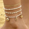 Detalle de conjunto de cuatro tobilleras bohemias con conchas y estrellas de mar en la arena - Estilo concha estrella de mar dorada de 4 piezas (26572-gold)