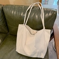 Gebreide shopper in gebroken wit met visgraatmotief en magnetische sluiting op bank - Beige Gestreept