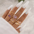 Close-up of five-piece gold ring set with purple gemstones and Love lettering on hand - Gold Heart Letter And Purple Zircon Assortment (24126-gold)