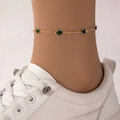 Elegante tobillera dorata con piedras verdes brillantes llevada con zapatillas blancas - Dorado con Gema Verde (15633-2-verde)