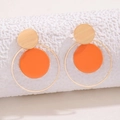 Detalle de pendientes geométricos dorados y naranjas con aros metálicos minimalistas - Naranja