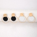 Detalle de pendientes geométricos dorados con discos negros y blancos en aros - Conjunto Negro Y Blanco