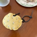 Detailansicht der gelben bestickten Kopfhörertasche mit Blumen auf rustikalem Holztisch - Gelbe Blumen Bestickt
