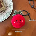 Close-up of cute strawberry plush bag charm with embroidery on a wooden table - Tomato Pendant