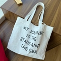 Borsa tote in nylon bianco con testo My Journey posata su gradini in legno scuro al sole - Stile Stampato Bianco