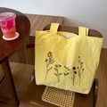 Leuchtend gelbe Nylon-Tragetasche mit bunten Blumenstickereien und stabilen Doppelgriffen - Gelb
