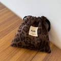 Nahaufnahme der dicken Plüsch-Beuteltasche mit Leopardenmuster und BYBR-Stoffetikett - Kordelzugbeutel / Braun Lächeln Leopard