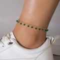 Close-up of gold chain anklet with green faceted beads worn with white sneakers - Green Faceted Bead Anklet Style (23120-1)