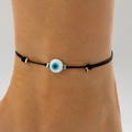 Detailed view of a black cord ankle bracelet with blue evil eye bead and silver charms - Woven Cord Anklet / White