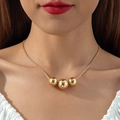 Dettaglio di una collana a catena serpente dorata con tre perle lucide su una modella - Collana a Catena a Serpente con Tre Perle / Oro